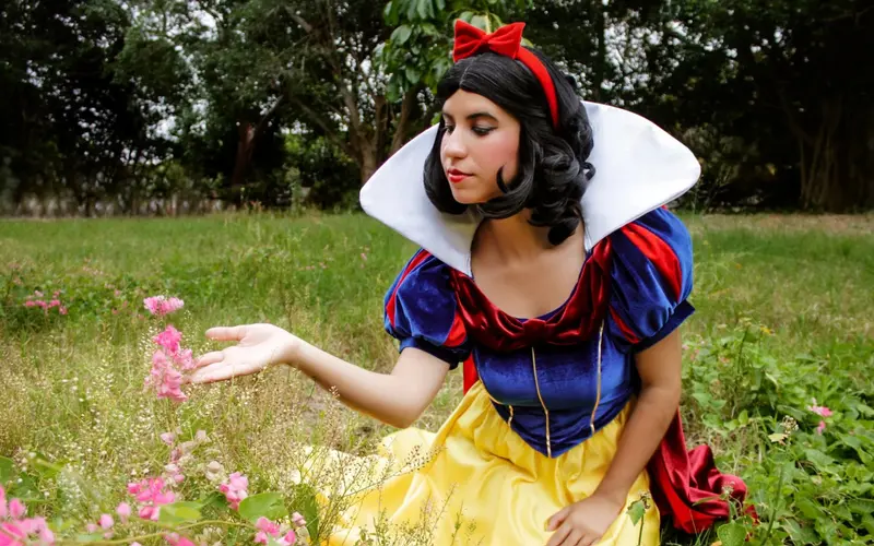 Blancanieves sentada junto a las flores del jardín